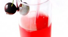 Vaso con zumo de cerezas decorado con unas cerezas